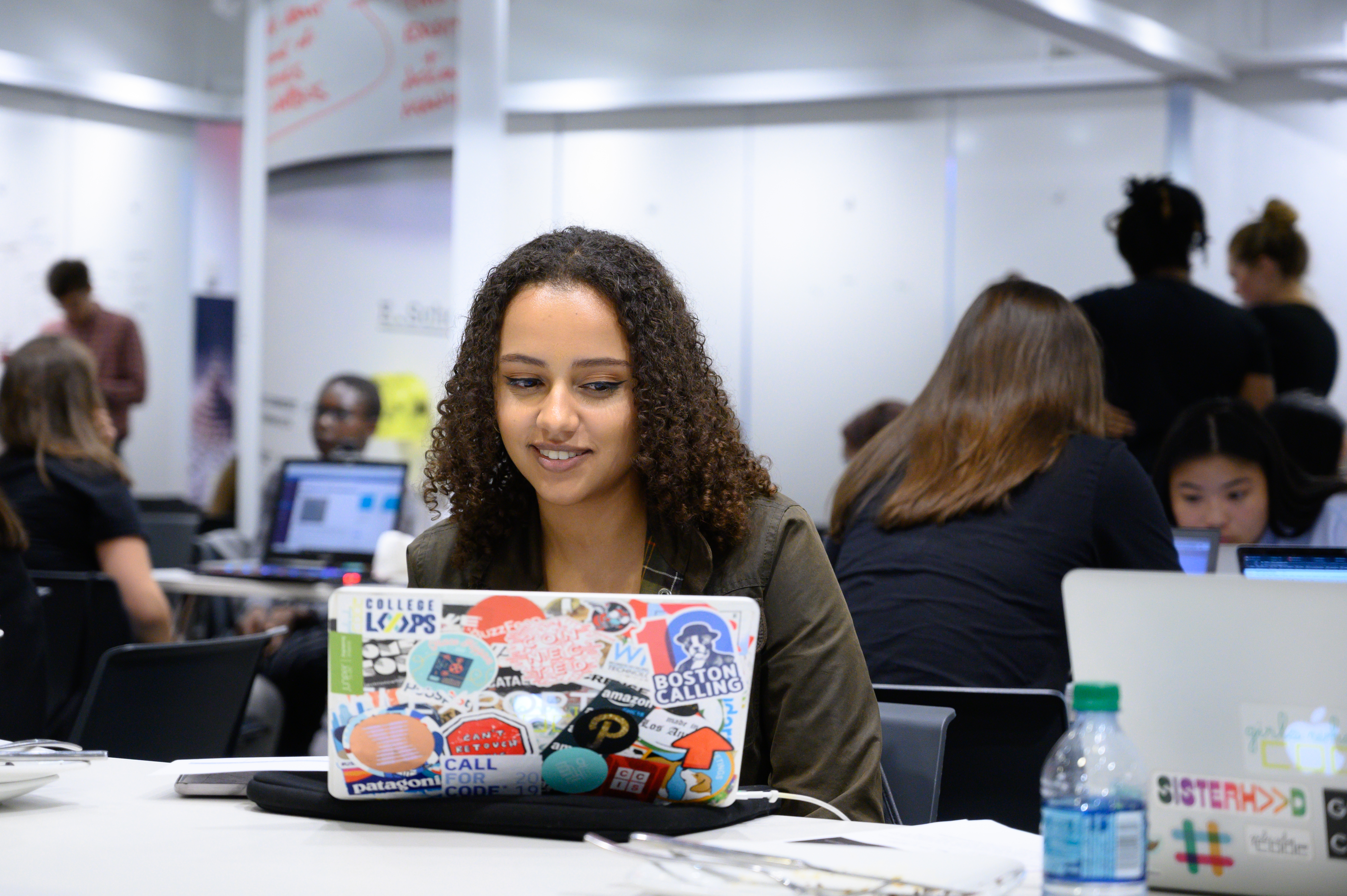 Curly haired girl sitting in front of a laptop